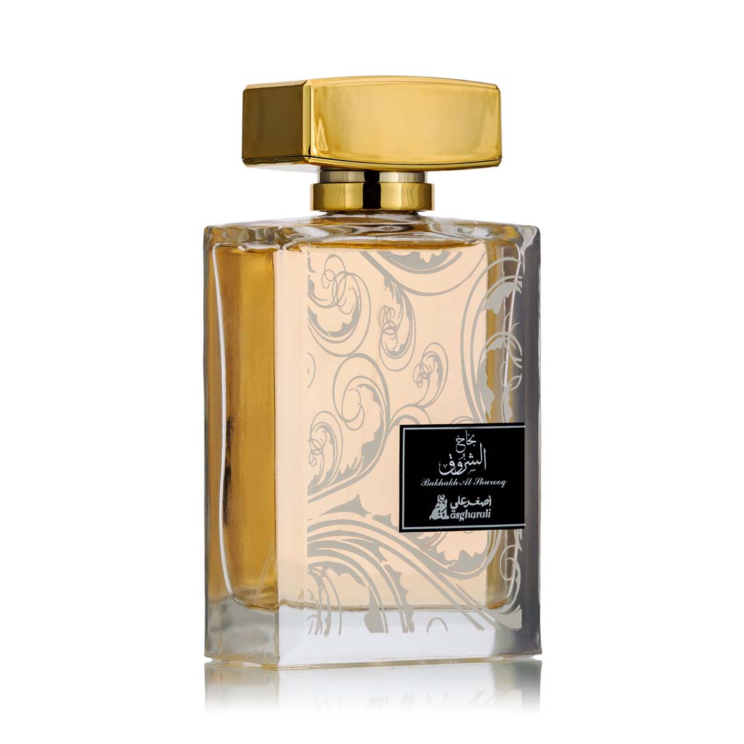 A 100ml bottle of Bakhakh Al Shurooq perfume with a gold-colored cap and a label featuring Arabic script. The bottle is clear with a decorative floral pattern etched into the glass.