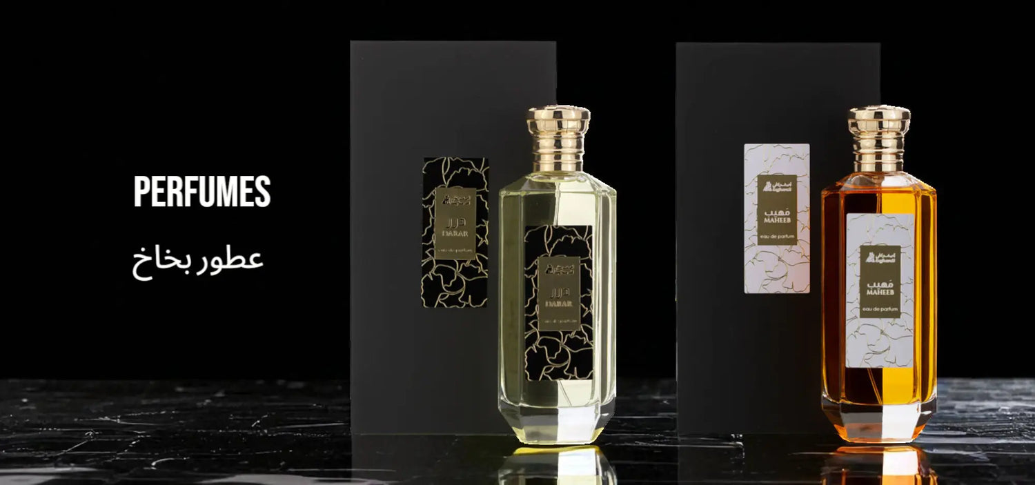 Two perfume bottles on a black marble surface with 'Perfumes' text.